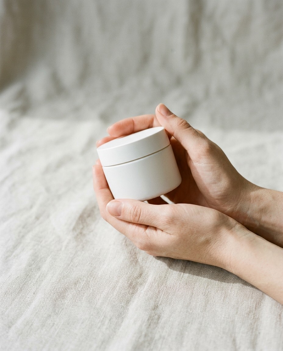 Mains tenant un pot de crème fini